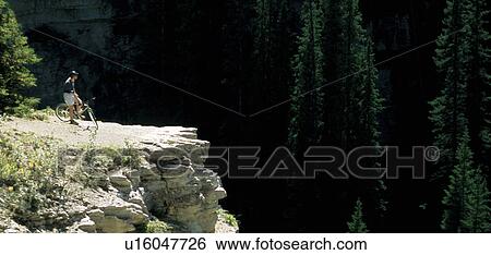 Cyclist looking over cliff View Large Photo Image Stock Photograph - Cyclist looking over cliff. Fotosearch