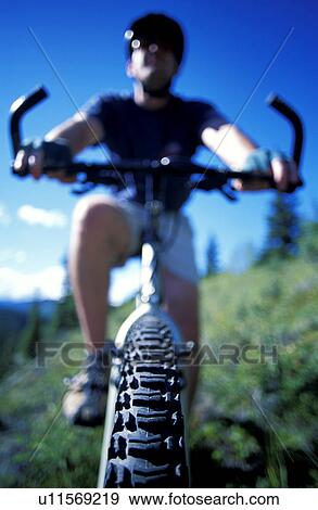 Stock Photo - Cyclist on mountain bike on hillside. Fotosearch