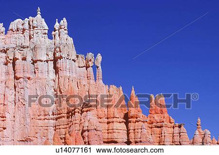 Stock Image - Edge of red rock canyon with blue sky background.. Fotosearch