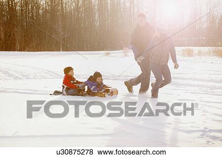 Family goes tobogganing View Large Photo Image Stock Photo - Family goes tobogganing. Fotosearch
