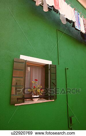 Flowers displayed on window sill of a colourful home with laundry hanging to dry on the Island of Burano Venetian Lagoon Italy View Large Photo Image Stock Photo - Flowers displayed on window sill of a colourful home with laundry hanging to dry on the Island of Burano Venetian Lagoon Italy. Fotosearch