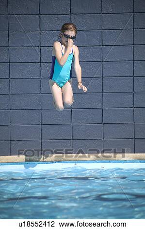 Stock Image - Girl jumps into the pool. Fotosearch