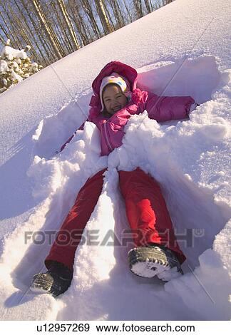 Stock Photo - Girl making a snow angel. Fotosearch