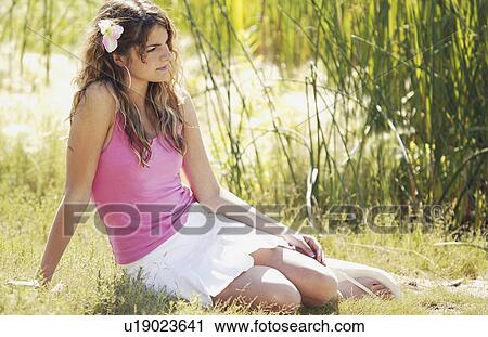 Stock Image - Girl posing in grass. Fotosearch