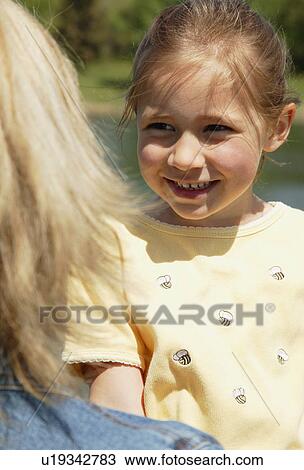 Stock Image - Girl smiles at mother. Fotosearch