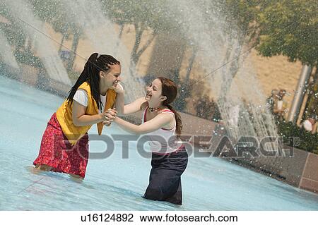 Stock Image - Girls have a water fight. Fotosearch
