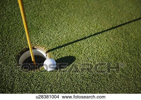 Picture - Golf ball close to pin. Fotosearch