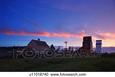 Stock Image - Grain elevators at sunset. Fotosearch