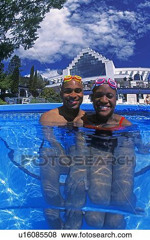 Stock Photo - Happy couple having fun in swimming pool. Fotosearch