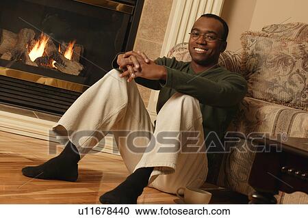 Stock Image - Happy in front of fireplace. Fotosearch