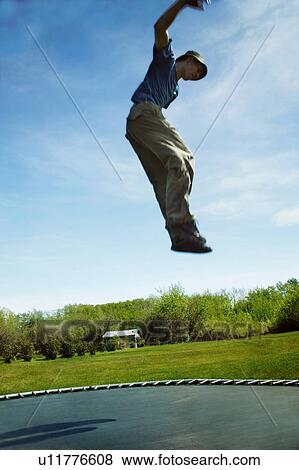 Jumping on a trampoline View Large Photo Image Stock Photo - Jumping on a trampoline. Fotosearch