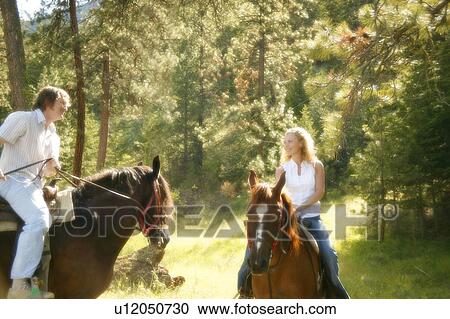 Stock Image - Man and woman on horseback. Fotosearch
