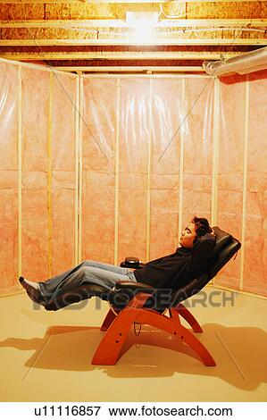 Stock Photo - Man listens to music in unfinished room. Fotosearch