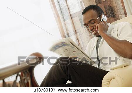 Stock Photo - Man reading the newspaper at home. Fotosearch