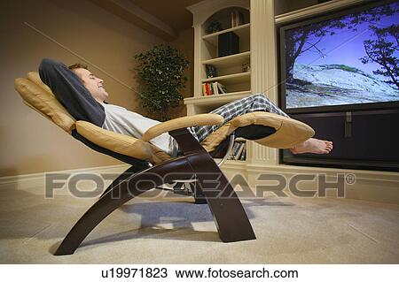 Man relaxes in front of television View Large Photo Image Stock Image - Man relaxes in front of television. Fotosearch