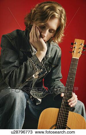 Stock Image - Man sitting with guitar. Fotosearch