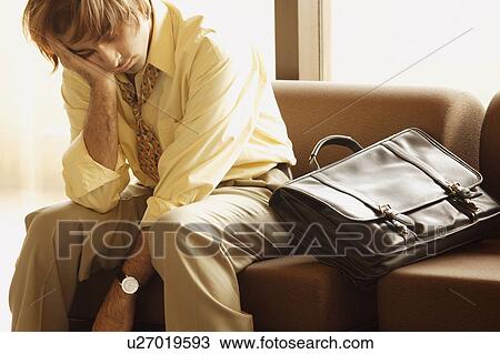 Stock Image - Man sleeps in airport. Fotosearch