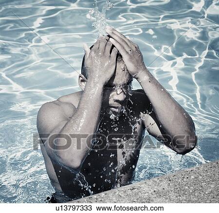 Stock Image - Man splashing in pool. Fotosearch