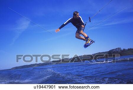 Stock Image - Man wakeboarding on coal Lake Alberta Canada. Fotosearch
