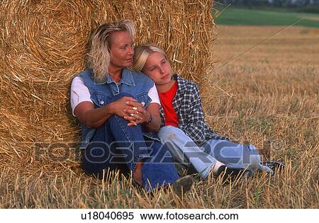 Stock Photography - Mom and daughter relaxing in the hayfield. Fotosearch
