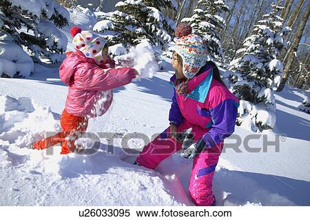 Stock Photography - Mother and Daughter having a snowball fight. Fotosearch