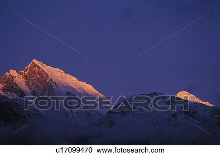 Stock Image - Mountain peaks at sunset. Fotosearch