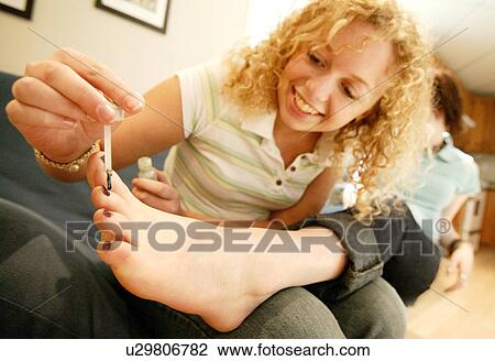 Painting toenails View Large Photo Image Stock Image - Painting toenails. Fotosearch
