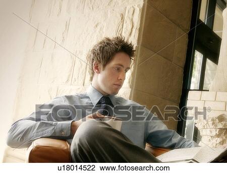 Stock Image - Passing time with coffee and a paper. Fotosearch