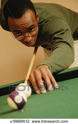 Stock Image - Playing a game of pool. Fotosearch