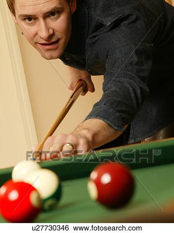 Stock Photograph - Playing a game of pool. Fotosearch