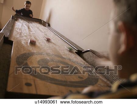 Playing a shuffleboard game View Large Photo Image Stock Image - Playing a shuffleboard game. Fotosearch