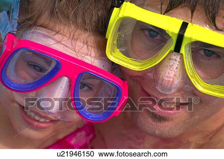 Stock Image - Portrait of father and daughter snorkeling. Fotosearch