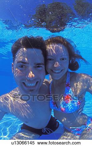 Portrait of happy couple underwater in swimming pool View Large Photo Image Stock Photography - Portrait of happy couple underwater in swimming pool. Fotosearch
