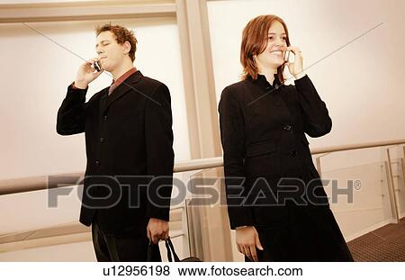 Professional couple on cell phones View Large Photo Image Stock Photo - Professional couple on cell phones. Fotosearch