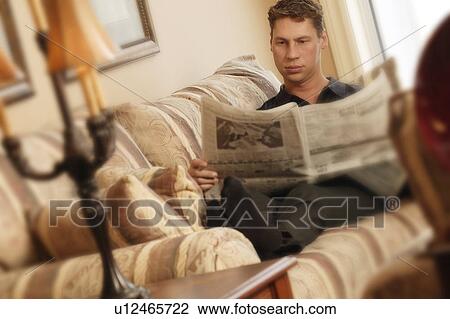 Stock Image - Reading paper relaxing. Fotosearch