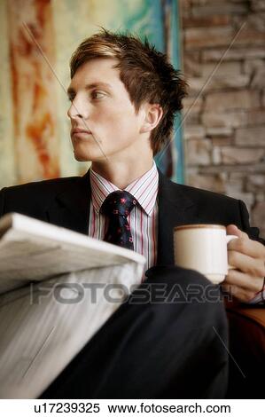 Stock Photography - Reading the newspaper and drinking a coffee. Fotosearch