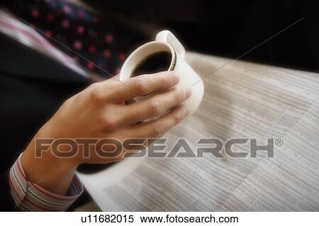Stock Photography - Reading the newspaper and drinking coffee. Fotosearch