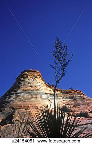 Stock Image - Rock hill with striations and blue sky. Fotosearch