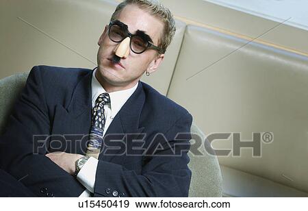 Serious businessman wearing Groucho Marx mask disguise View Large Photo Image Stock Photo - Serious businessman wearing Groucho Marx mask disguise. Fotosearch