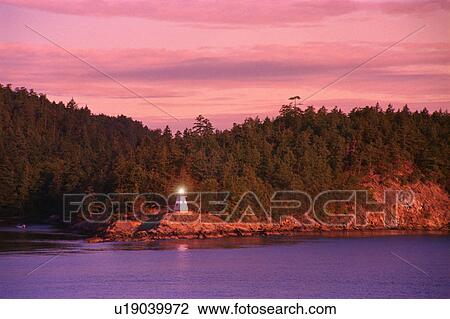 Small lighthouse with trees and hill behind View Large Photo Image Stock Image - Small lighthouse with trees and hill behind. Fotosearch