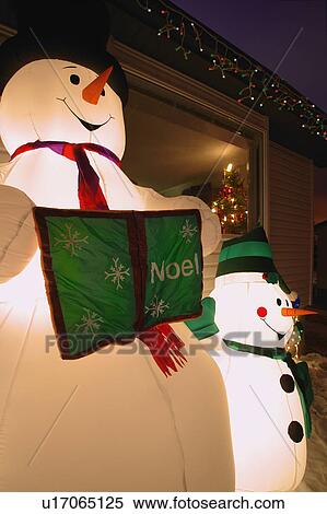 Stock Photography - Snowman Family and Christmas decorations outside Home. Fotosearch