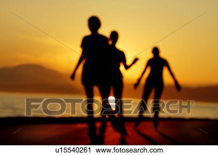 Stock Image - Soft focus of people and a sunset. Fotosearch