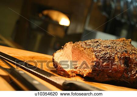 Stock Image - Still life with ham and knives. Fotosearch