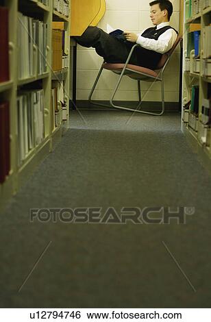Stock Photograph - Student studies in library. Fotosearch