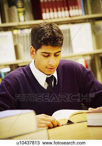 Stock Image - Student studying in library. Fotosearch