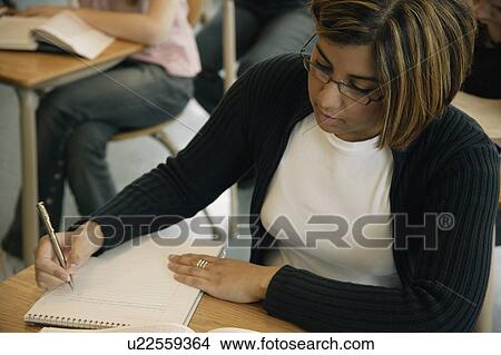 Picture - Student writes notes. Fotosearch