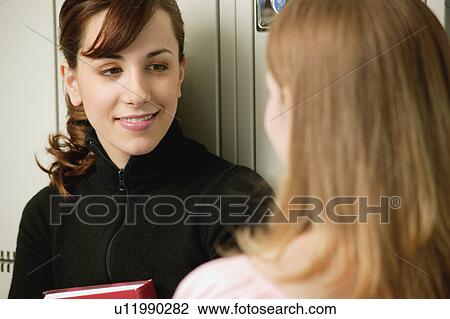 Students have a conversation at their lockers View Large Photo Image Stock Image - Students have a conversation at their lockers. Fotosearch