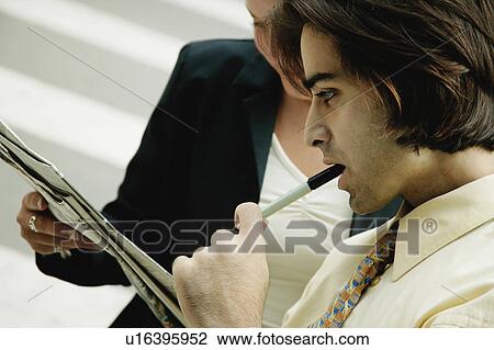 Stock Image - Studying a newspaper. Fotosearch
