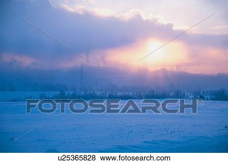 Stock Photo - Sunset through clouds in winter. Fotosearch