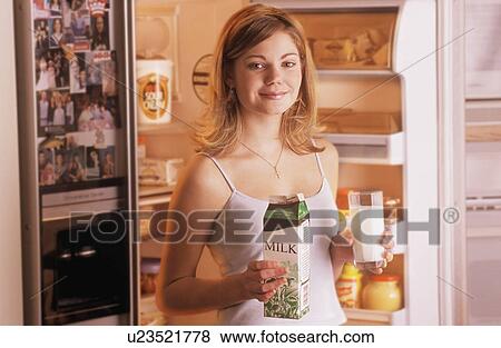 Stock Photo - Teenager getting milk from fridge. Fotosearch